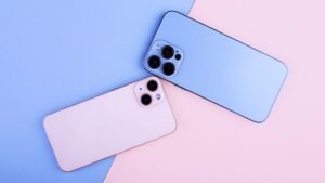 Deux iphone 13 reconditionnés rose et bleu, posés à plat